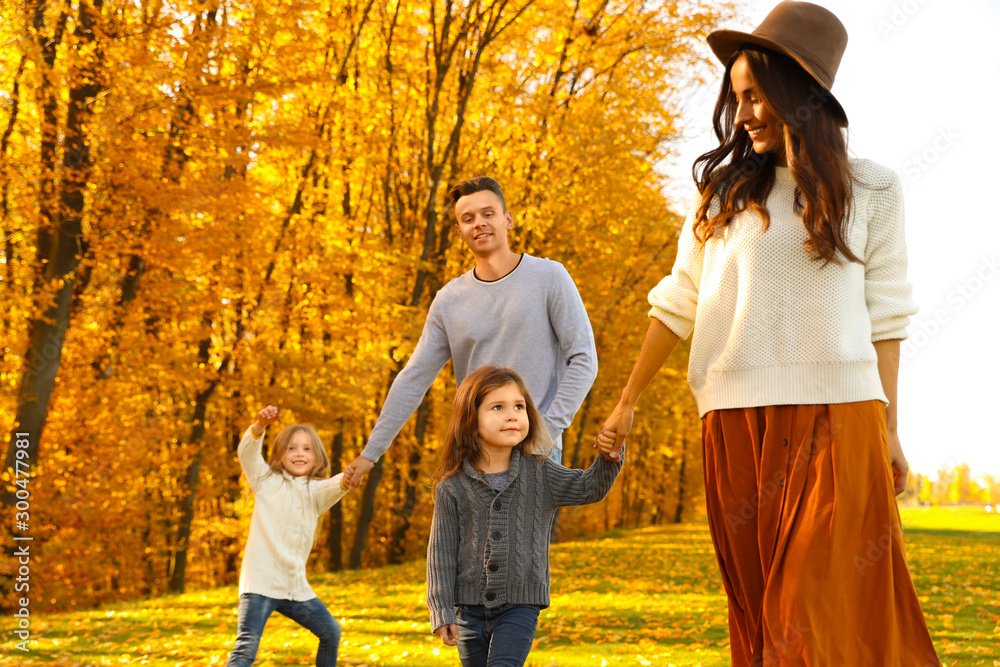 Fototapeta premium Happy family with little daughters walking in autumn park