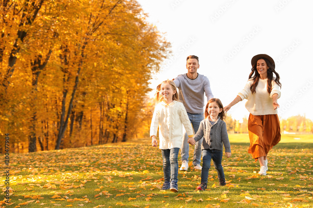 Happy family with little daughters having fun in park. Autumn park Happy family with little daughters having fun in park. Autumn park
