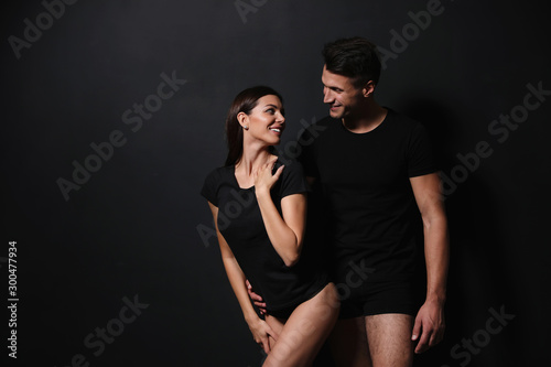 Young couple wearing underwear on black background