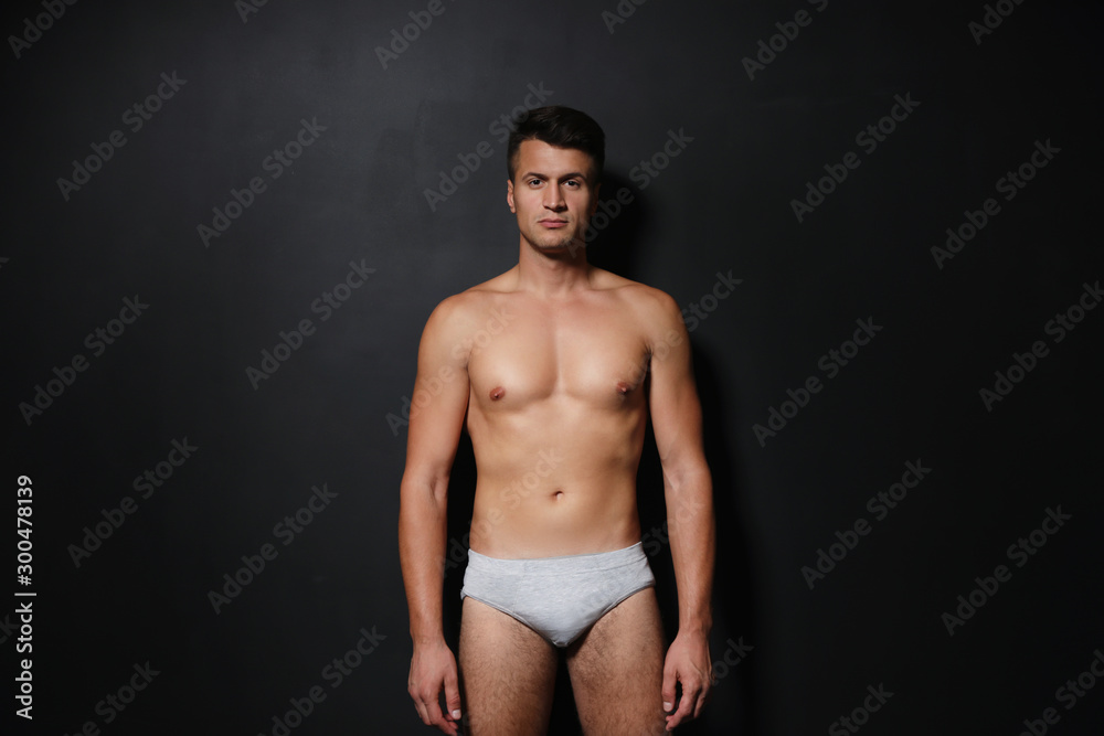 Naklejka premium Handsome man wearing underwear on black background