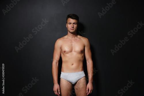 Handsome man wearing underwear on black background © New Africa