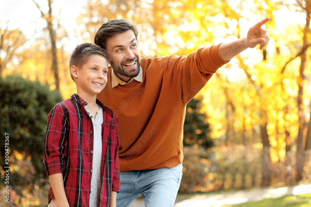 Happy father and son spending time in park. Autumn walk Happy father and son spending time in park. Autumn walk