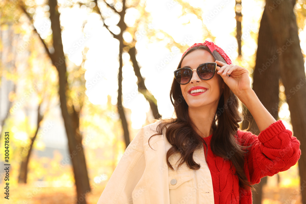 Beautiful woman wearing sunglasses in park. Autumn walk Beautiful woman wearing sunglasses in park. Autumn walk