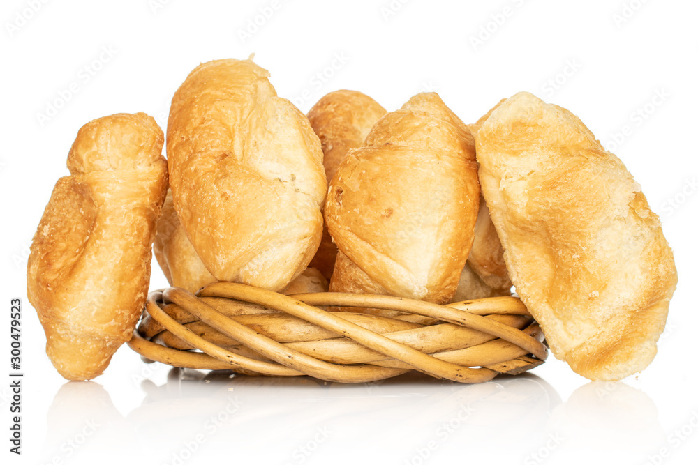 Group of five whole fresh baked mini croissant in wicker vine circle isolated on white background