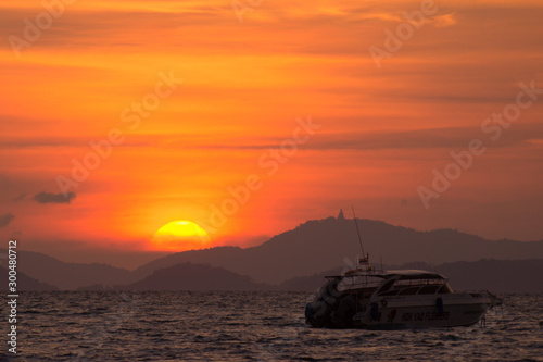 sunset on the sea with boat and mountain
