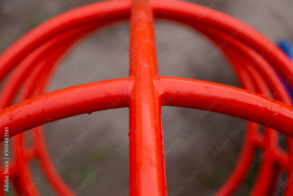 Red pipes in the playground close-up in raindrops