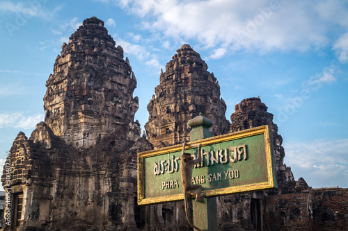 monkey hanging on a temple sign lopburi photo