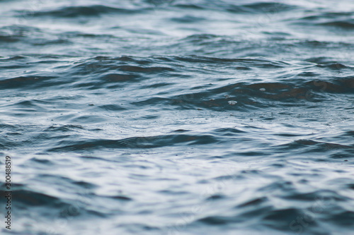 Beautiful   blue sea water surface with low waves. Seascape background. Calm Dark Sea Waves. Close-up  shallow focus.