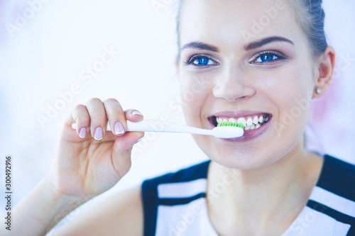 Young pretty girl maintaining oral hygiene with toothbrush.