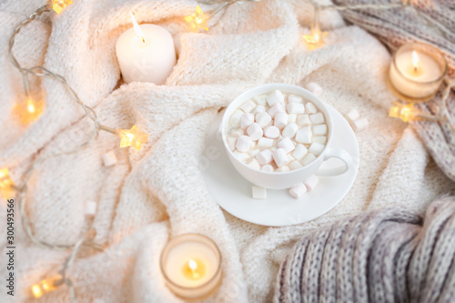 Warm knitted blanket, cup of coffee, marshmallows, Christmas lights, vintage toy, candles