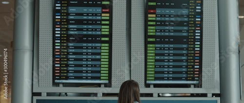 Woman looking at the airport display board checking for flight number, slow motion, BMPCC 4K