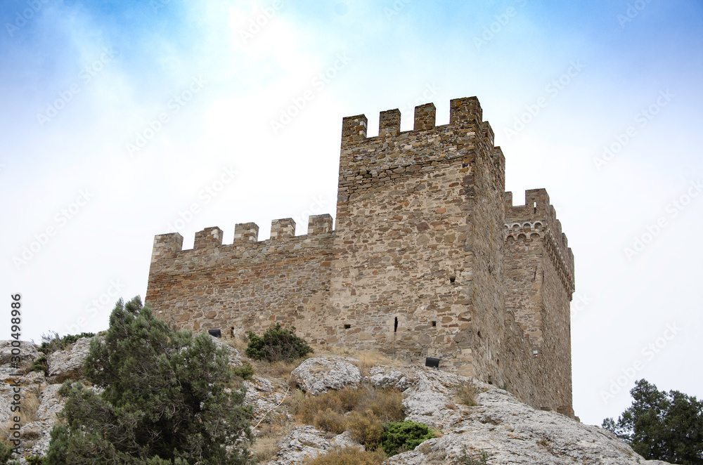 Tower of an old medieval fortress in the mountains.
