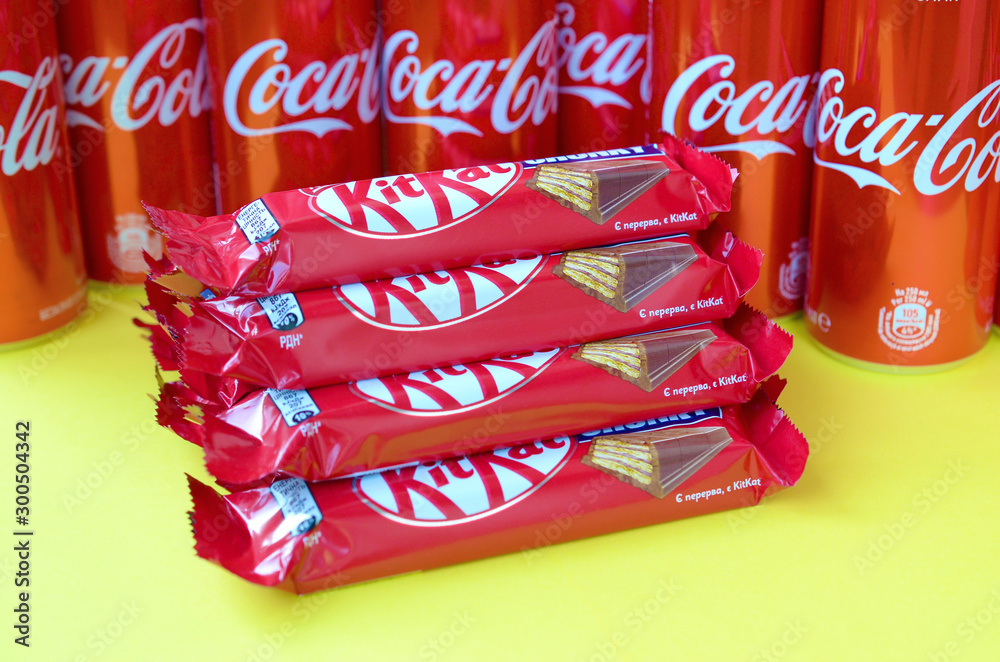 golf Parat hjemme Foto Stock Kit Kat chocolate bars in red wrapping lies on bright yellow  background with Coca Cola tin cans close up. Famous drink and chocolate  product | Adobe Stock