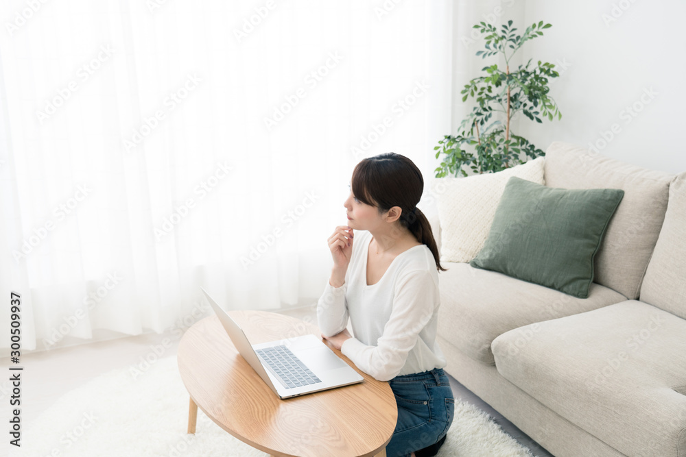 部屋でインターネットをする女性 部屋でインターネットをする女性