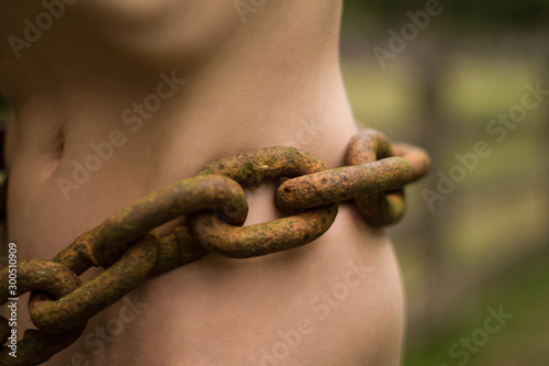 Принти на полотні A heavy rusted chain sits on the bare skin of the waist of a nude caucasian woma
