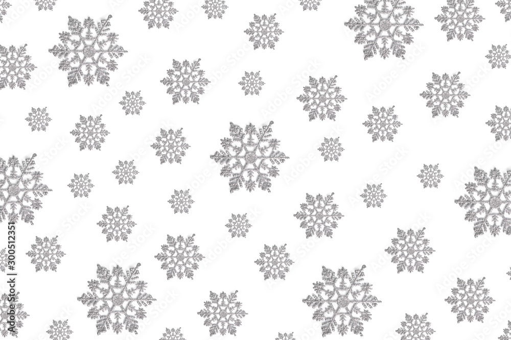 pattern of Christmas decor in the form of silver snowflakes on a white background. new year concept, top view, flat layout pattern of Christmas decor in the form of silver snowflakes on a white background. new year concept, top view, flat layout