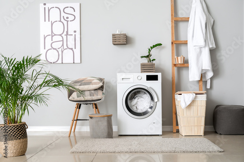 Interior of home laundry room with modern washing machine photo