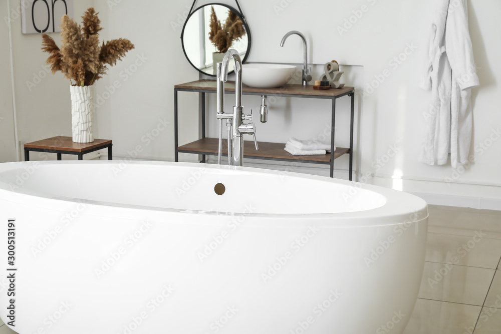 Modern ceramic bathtub in light interior - obrazy, fototapety, plakaty 