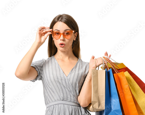 Surprised young woman with shopping bags on white background