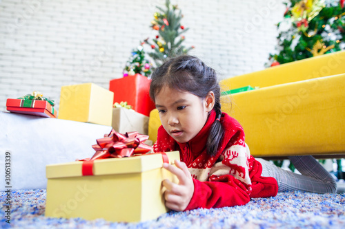 Cute asian child girl surprise with gift and holding beautiful gift box in hand on Christmas celebration