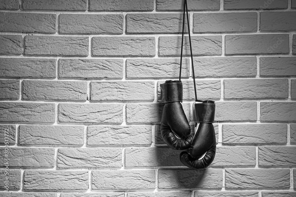Fototapeta Pair of boxing gloves hanging on brick wall