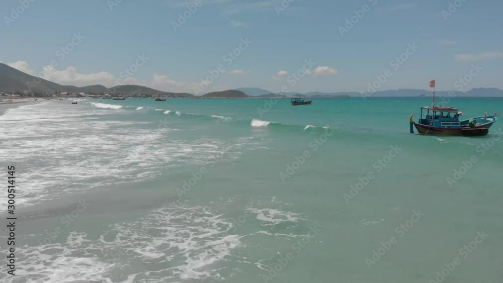 a flying camera shoots from top to bottom Nha Trang beach with many tourists, a wave and an umbrella a flying camera shoots from top to bottom Nha Trang beach with many tourists, a wave and an umbrella