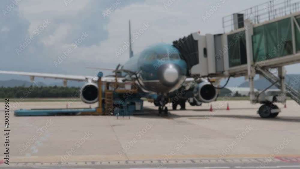 Dà Nang, Hai Chau District / Vietnam - 30.05.2019 Various airport service equipment passes by camera with a view of the runway, airplanes, flight bridge, mountains and clouds.