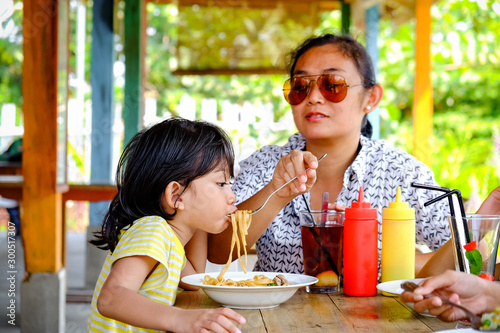 Southeast Asian Ethnicity Family Lifestyle, Mother Having Lunch Together with Her Kids at A Restaurant © AmpYang Images