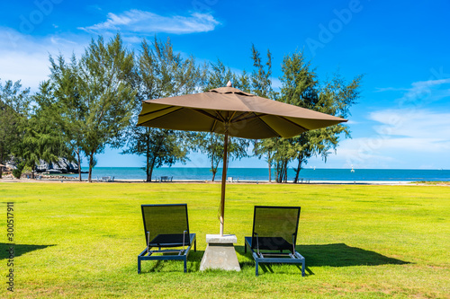 Beautiful outdoor landscape of sea and beach with umbrella and chair around there © siraphol