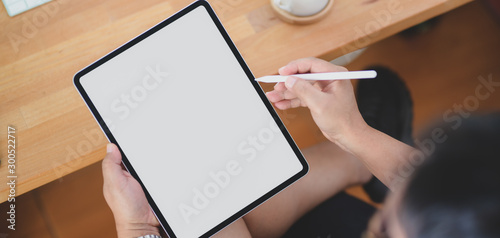 Close-up view of man working on his project with blank screen tablet