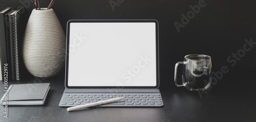 Close-up view of modern workplace with blank screen tablet with office supplies