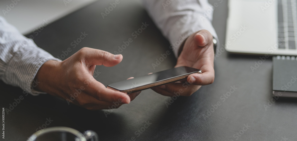 Close-up view of businessman looking for information on smartphone