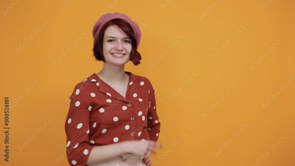 Beautiful caucasian young funny woman wearing pretty red shirt with polka dot on isolated yellow background looking smiling and showing victory sign Beautiful caucasian young funny woman wearing pretty red shirt with polka dot on isolated yellow background looking smiling and showing victory sign