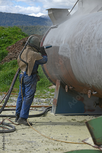 Foto engineer sandblasting a steel casing