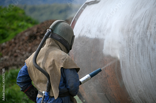 engineer sandblasting a steel casing