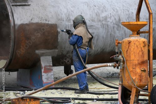 engineer sandblasting a steel casing photo