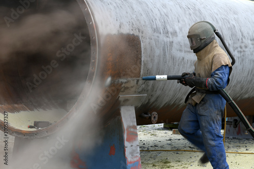 engineer sandblasting a steel casing