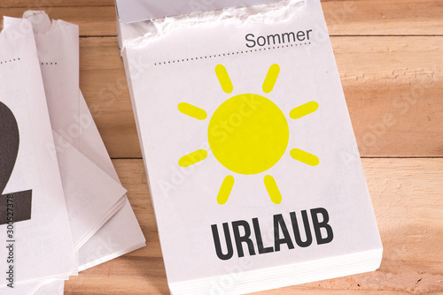 Ein Kalender, Sonne und Hinweis auf den Urlaub photo