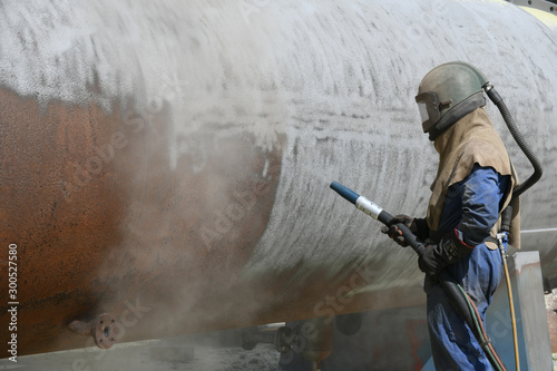Foto engineer sandblasting a steel casing