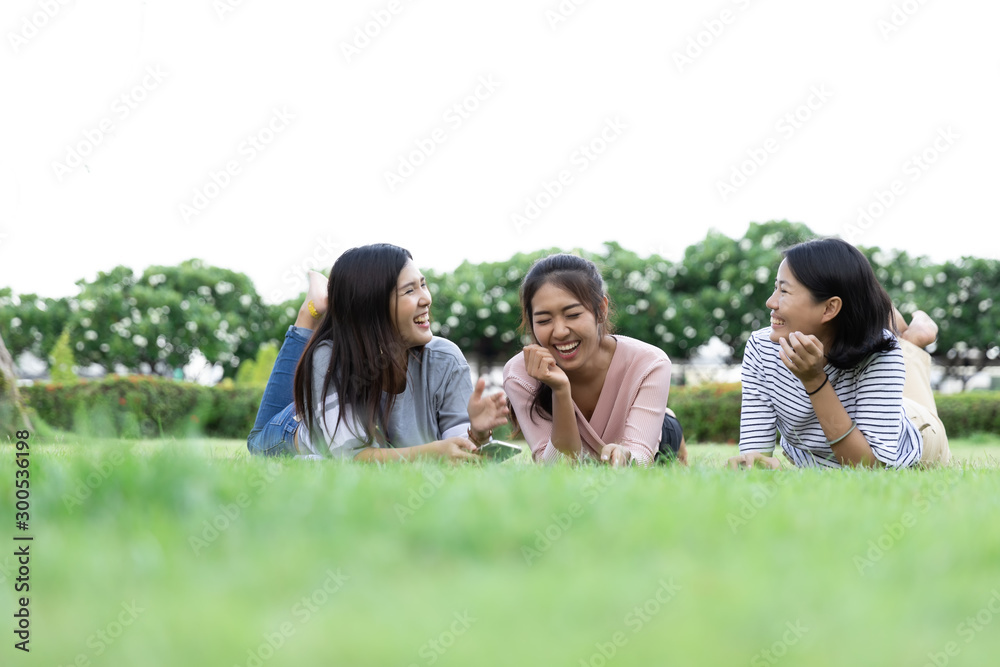 Group Cheerful young Asian woman in casual clothes three people laying down on grass laughing and talk together in the park. Happy vacations. with Copy space Group Cheerful young Asian woman in casual clothes three people laying down on grass laughing and talk together in the park. Happy vacations. with Copy space
