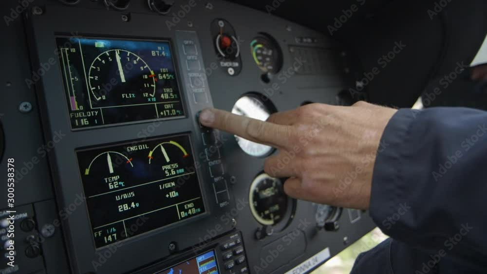 close up of helicopter cockpit intruments and pilots finger adjusting displays - during flight close up of helicopter cockpit intruments and pilots finger adjusting displays - during flight
