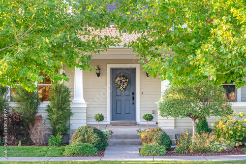 Canvas Print Front door of a home surrounded by leafy trees