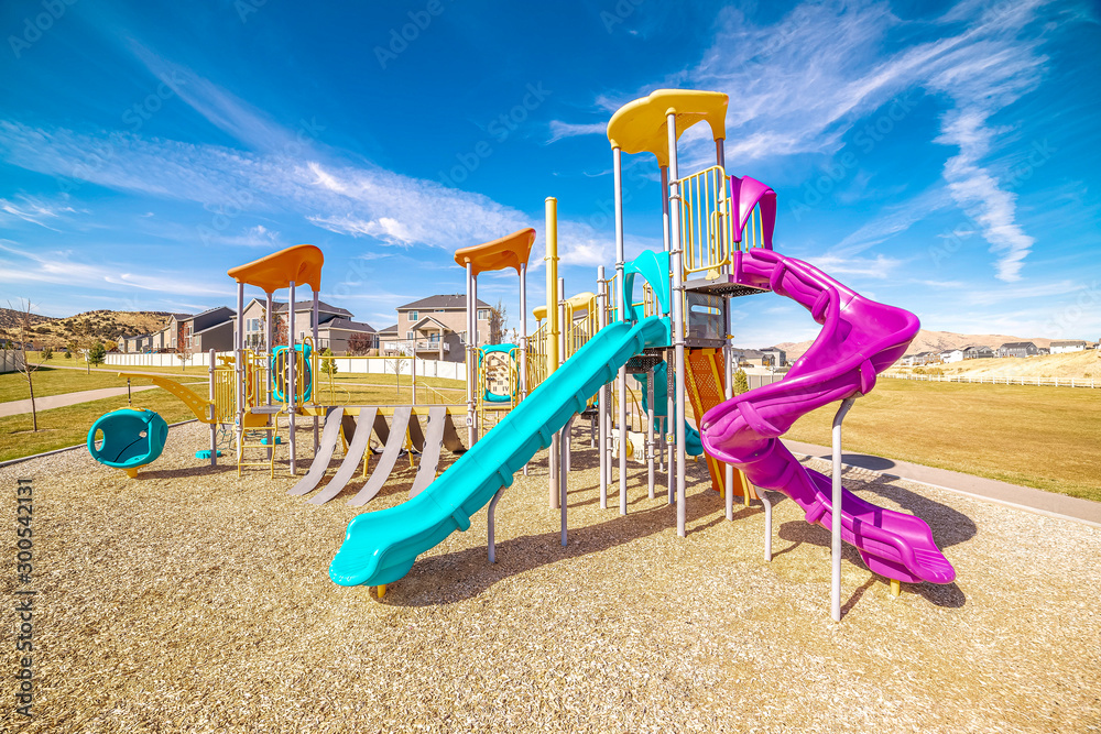 Colorful blue and purple slides in kids playground - obrazy, fototapety, plakaty 