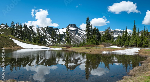 Snow mountain lake landscape with blue sky and clouds.