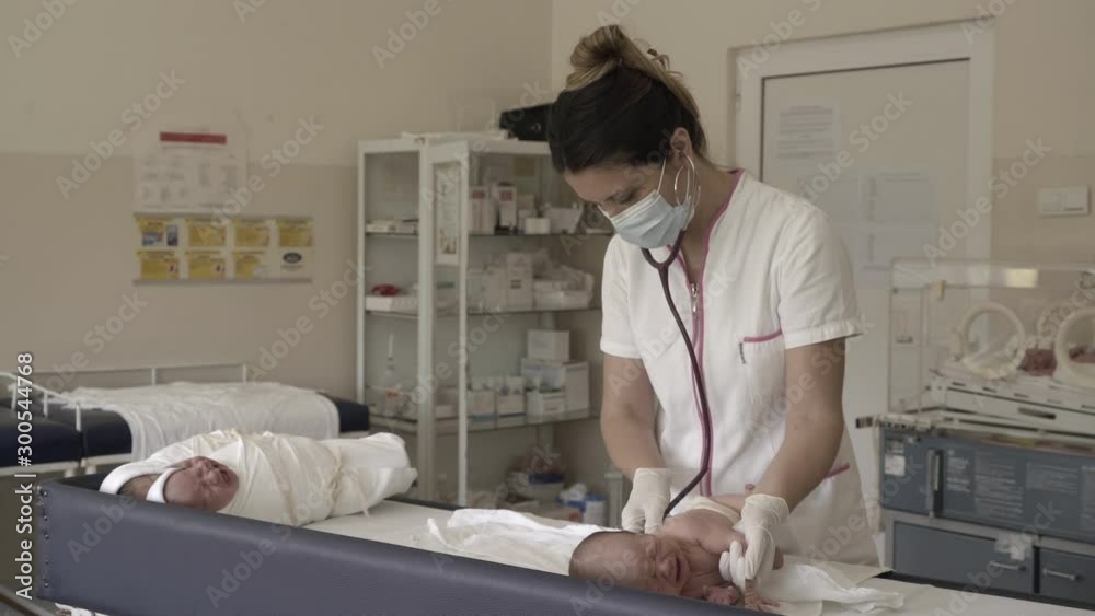 Portrait of female doctor pediatrician during newborn babies examination in office room. Portrait of female doctor pediatrician during newborn babies examination in office room.
