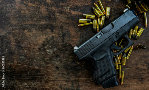 Guns and ammunition placed in a wooden table,Short guns and ammunition placed on a black background table,Guns and ammunition are ready to use. Noisy weapon