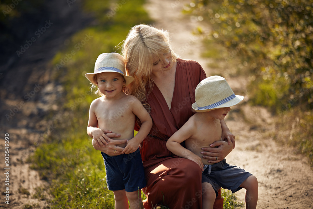 Fototapeta premium Cheerful mother with her two adorable twin-sons