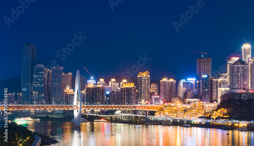 chongqing city skyline at night, with bridge and river. © duan