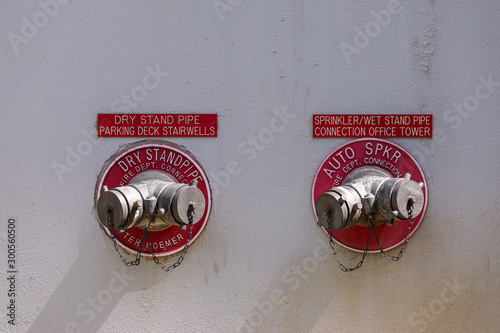 A dry standpipe and  sprinkler/wet standpipe on a grey wall