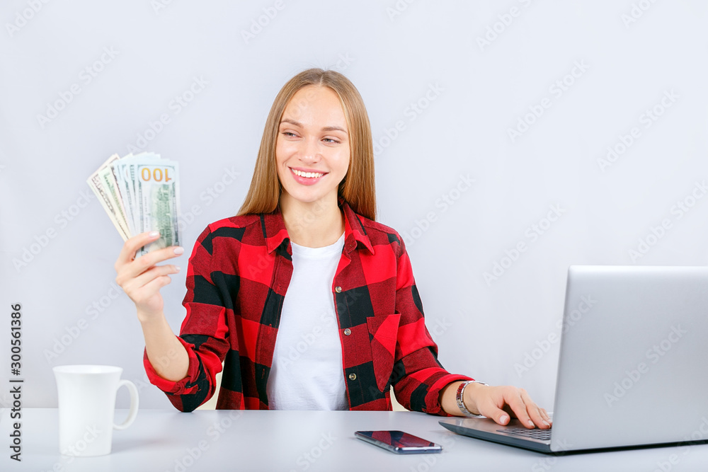 Young woman working online on computer earning money dollar bills banknotes. Cash back woman. Young woman working online on computer earning money dollar bills banknotes. Cash back woman.